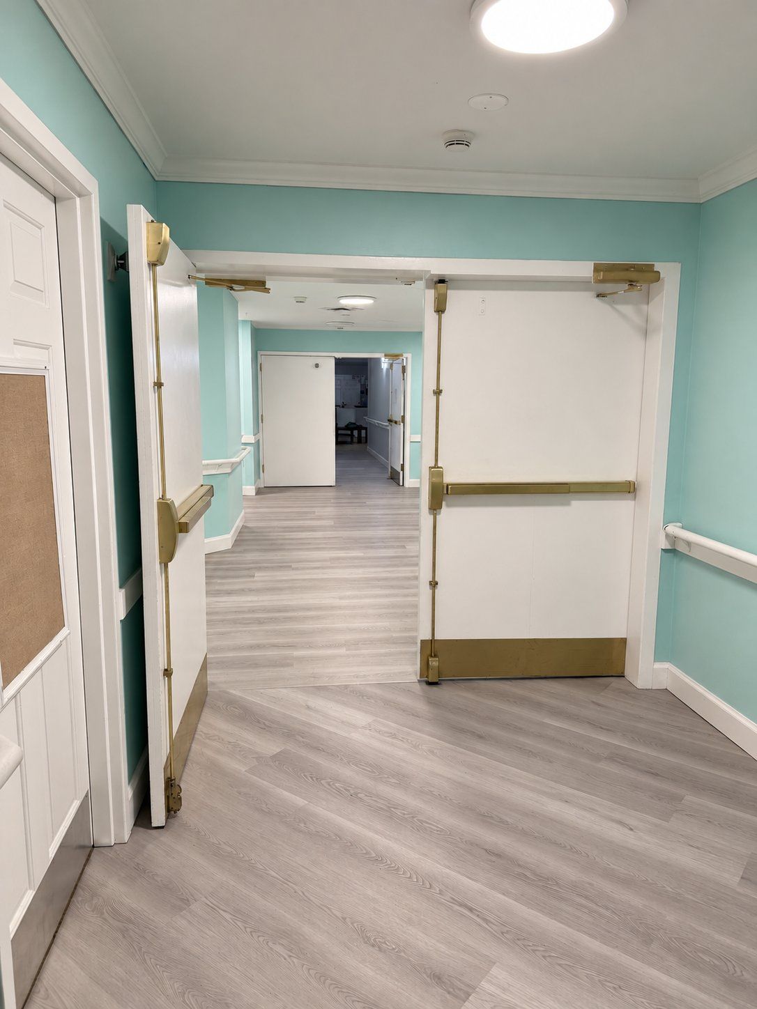 A hallway at Oak Grove Recovery in Westerville, Ohio, with a pair of double doors held open onto a long corridor