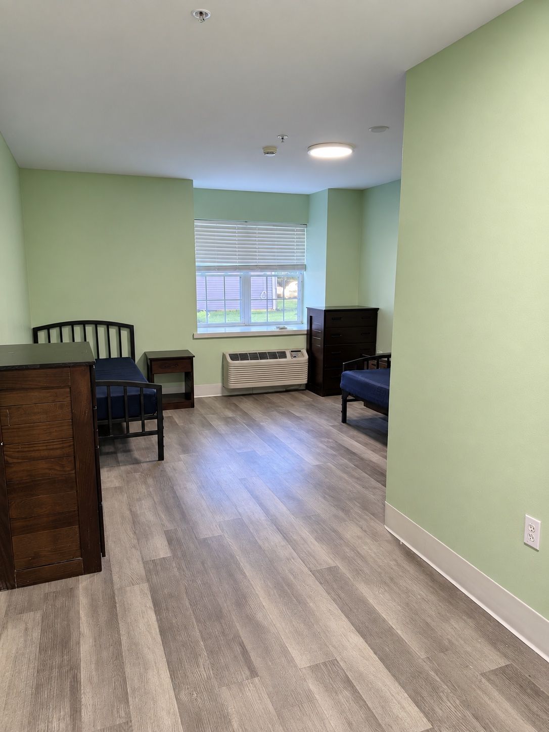 A second two-bed resident room at Oak Grove Recovery in Westerville, Ohio, with green walls and a window