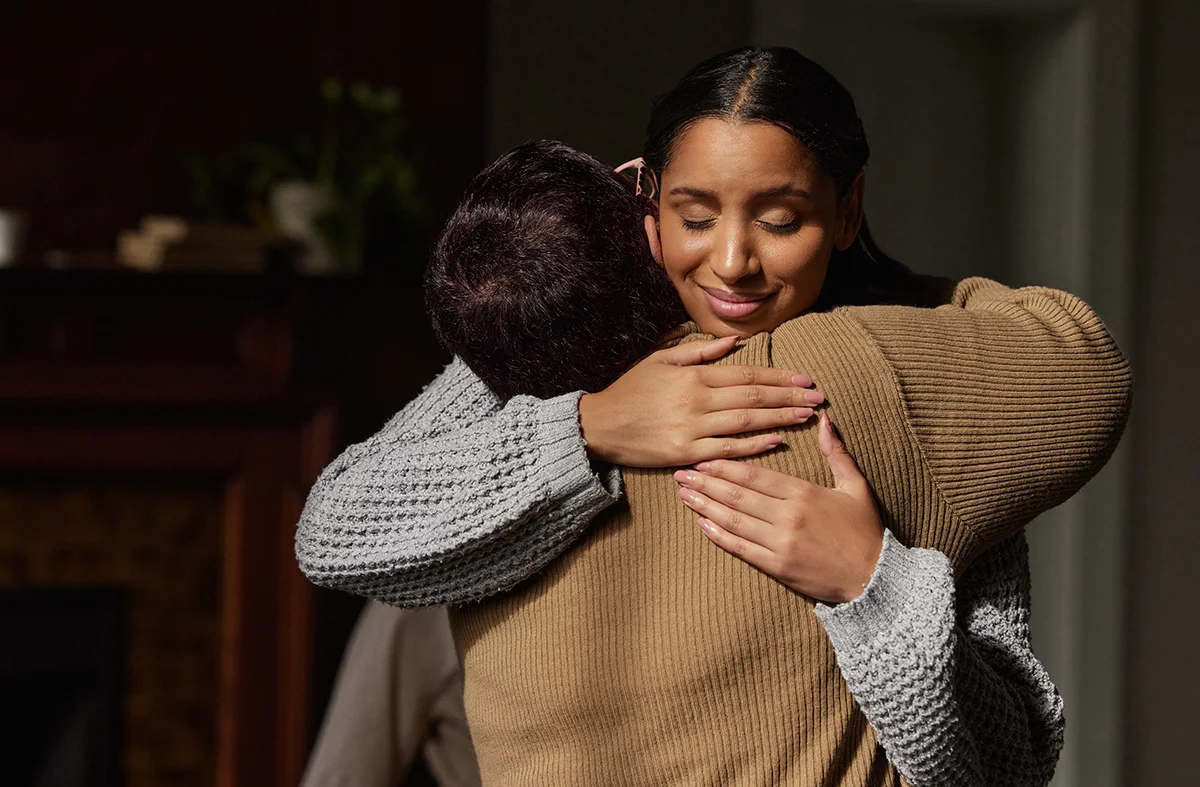 Two people hugging after talking about paying for addiction treatment