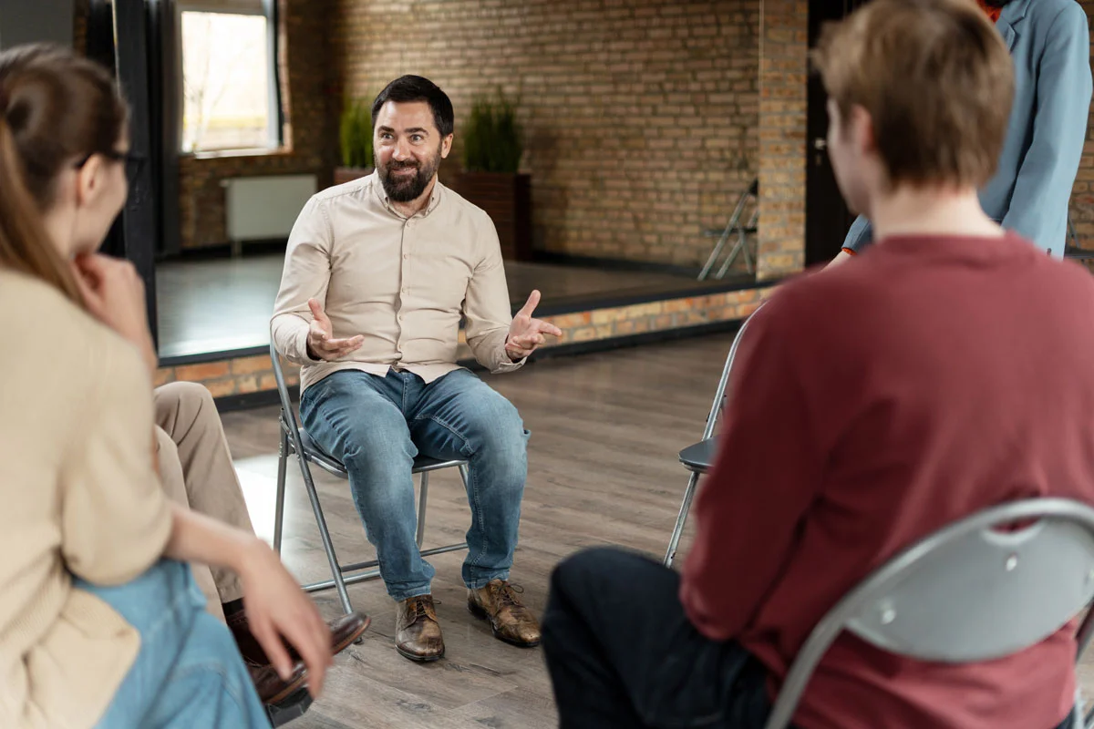 a man addresses a group during therapy after Adderall detox