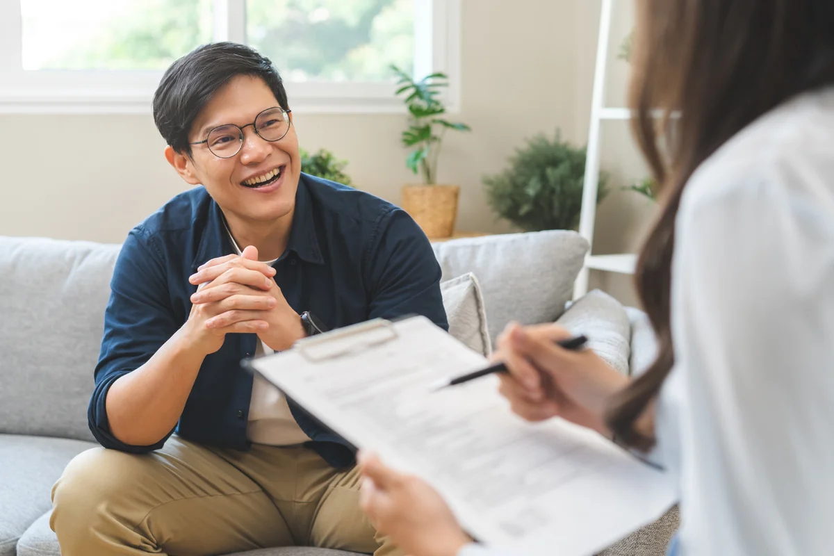 Man smiling while chatting with psychiatrist